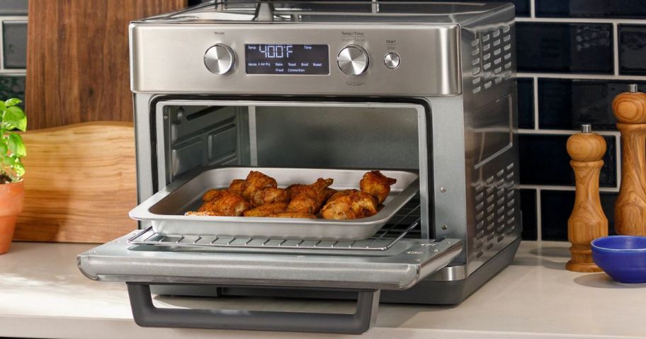 Counter top with a GE Air Fry 6-Slice Stainless Steel Convection Toaster Oven on it with chicken wings inside