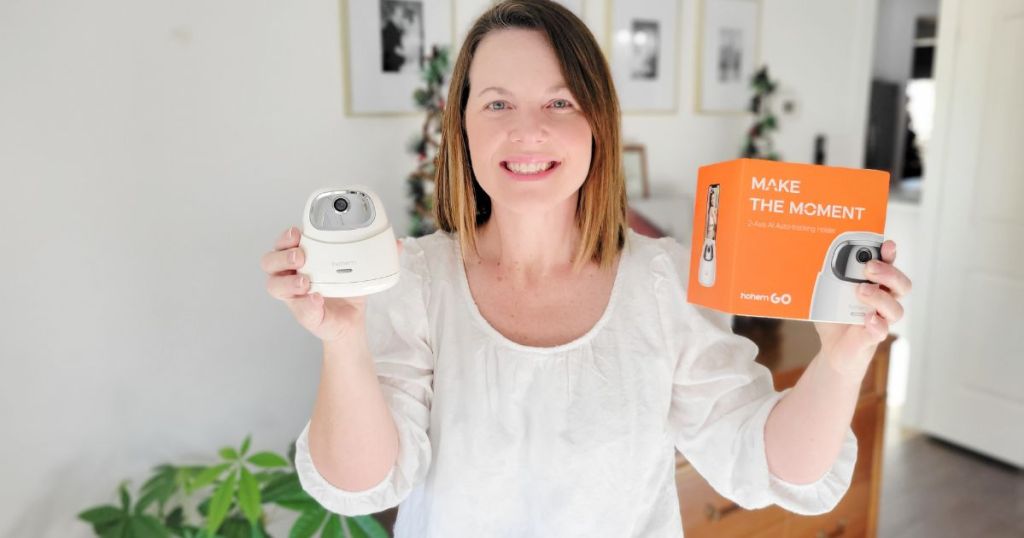 woman holding up a white tripod and it's box