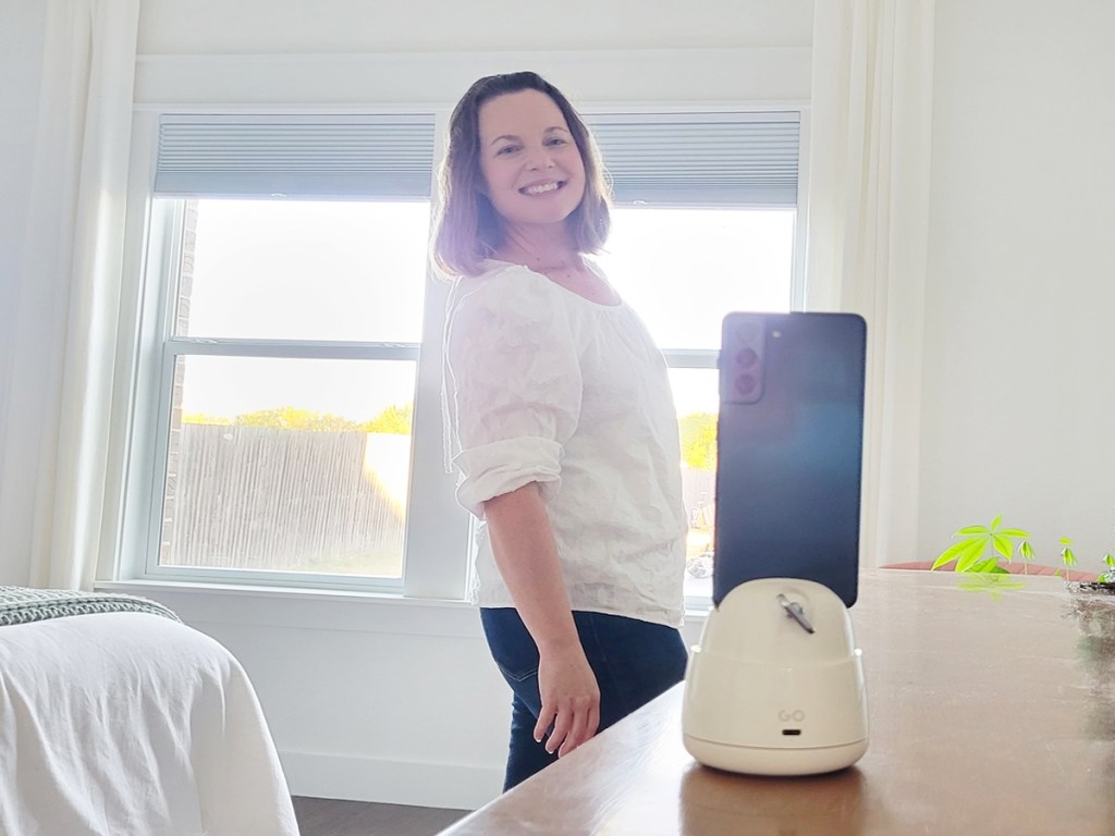 woman smiling at phone on tripod