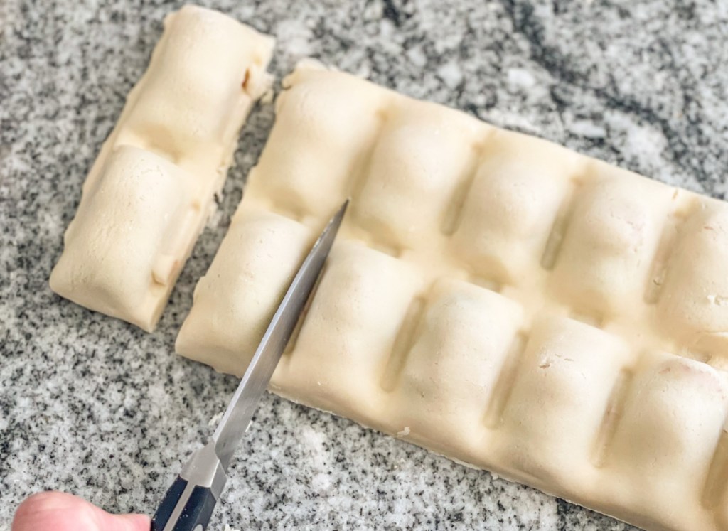 cutting homemade pizza bites into individual pieces