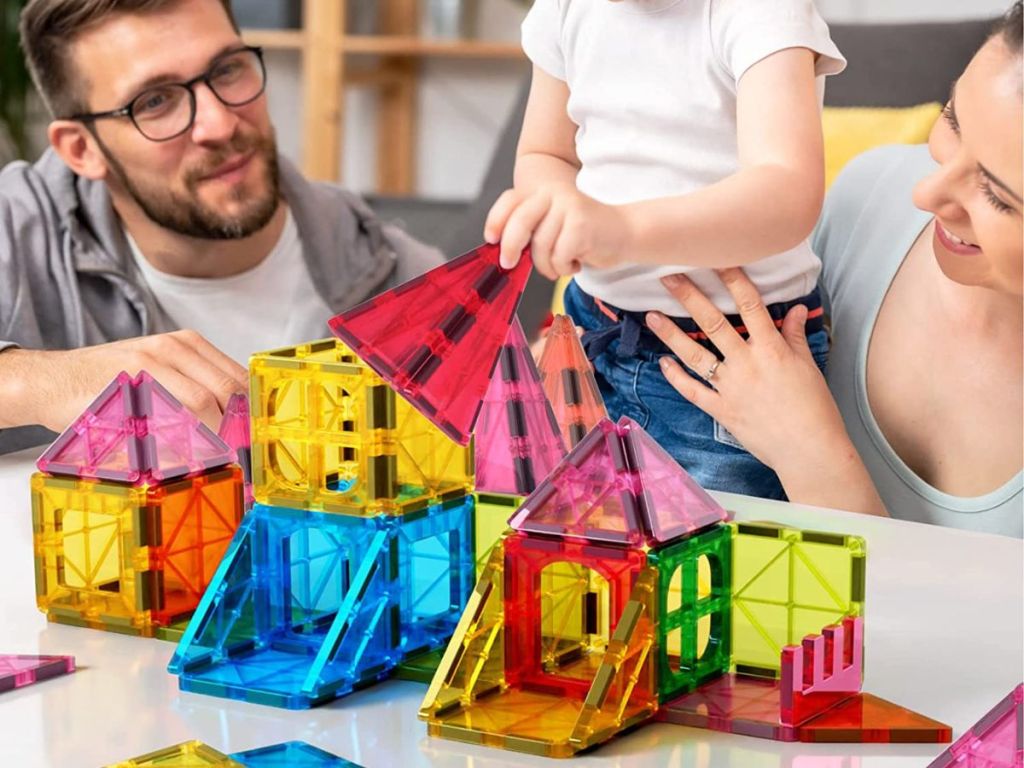 man woman and kid playing with magnetic blocks