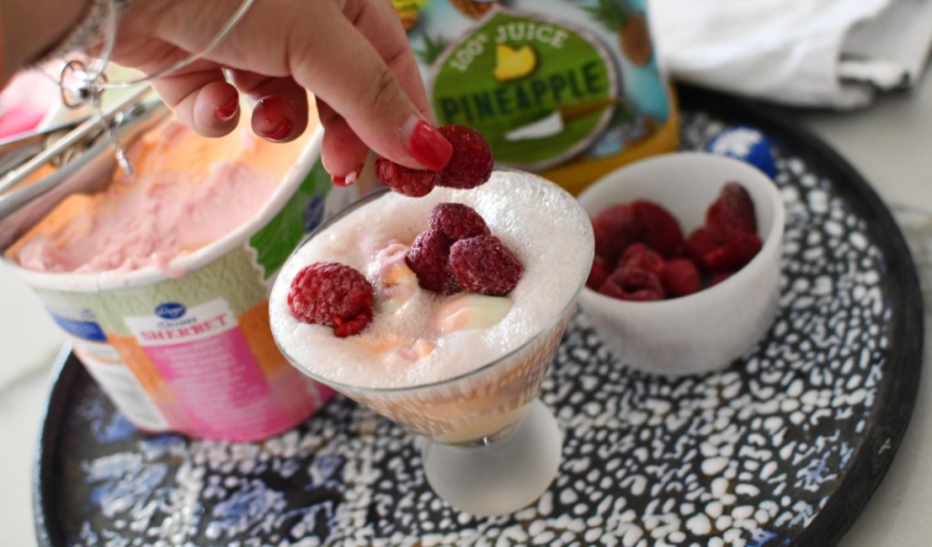 Topping a mocktail with raspberries