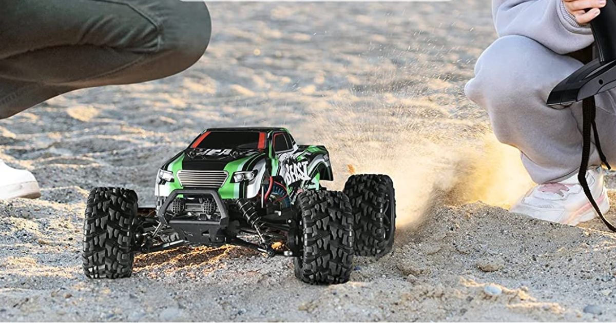 kids using green RC truck in sand