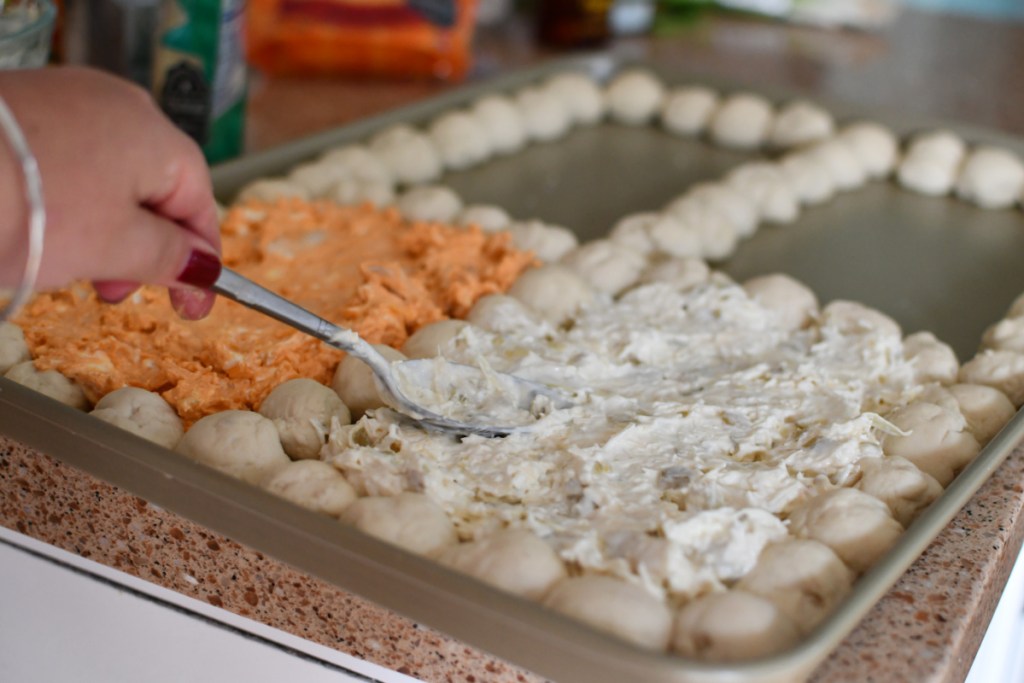 Spreading cheese dip onto a baking sheet