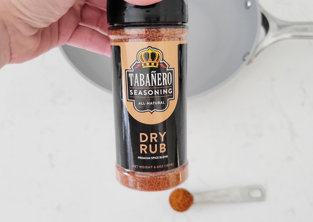 holding bottle of Tabañero Dry Rub Seasoning