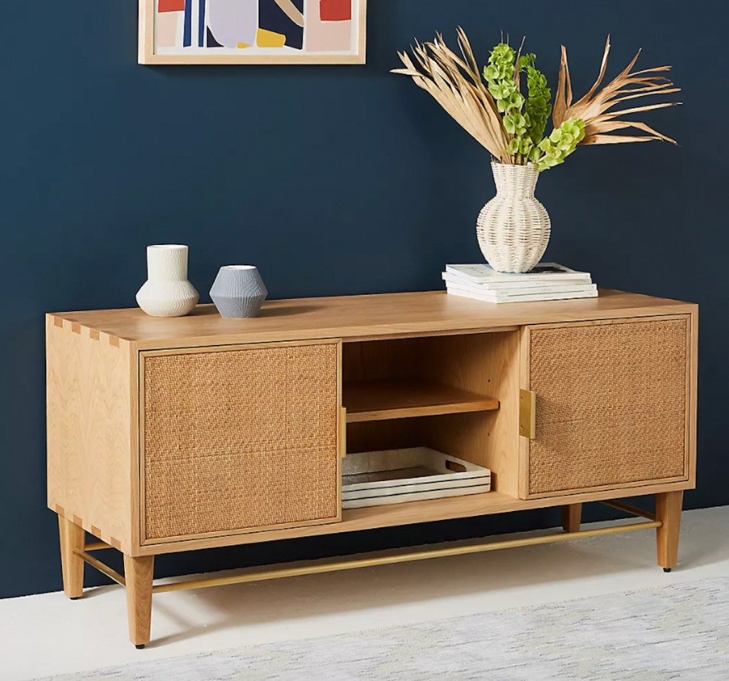 caned console table with various decor in styled living room 