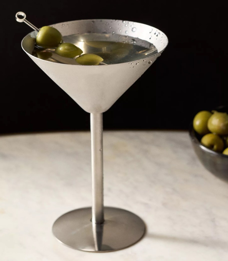 silver martini glass with olives inside