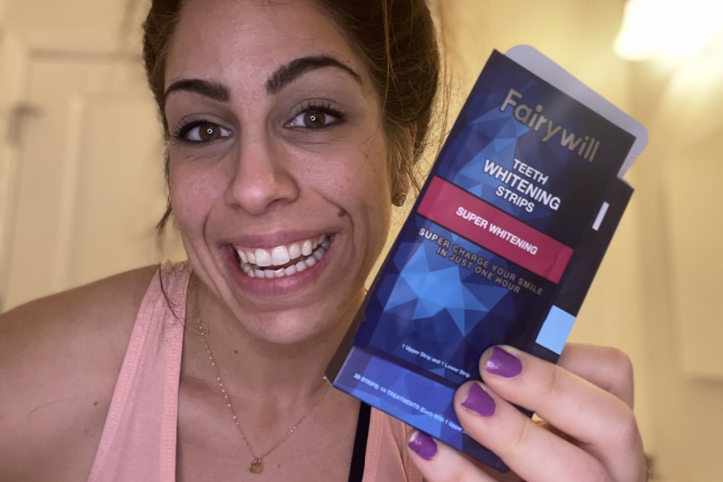 woman holding teeth whitening strips