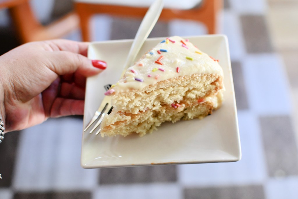 holding a slice of vanilla wacky cake