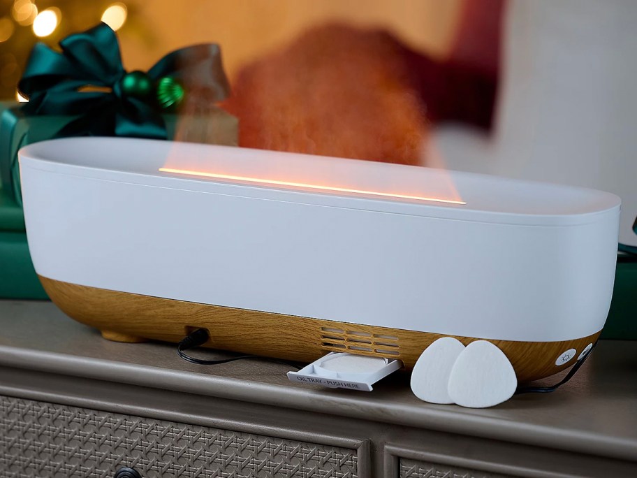 white and brown humidifier on table with mist flame and essential oil pads in front 