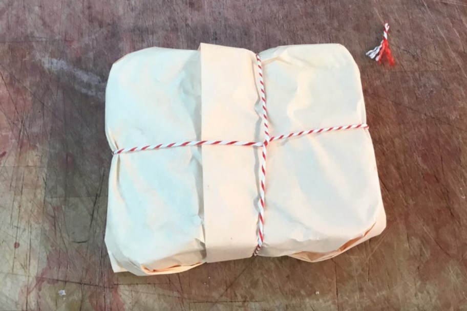 beef wrapped in white butcher paper with red string