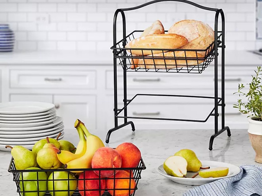 2 tier basket stand with one basket full of fruit on table