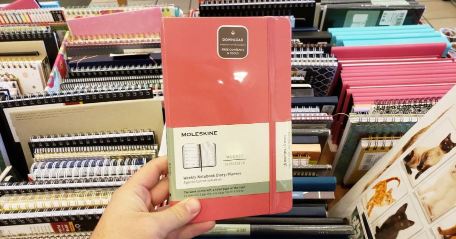 moleskine planner being held by hand in store