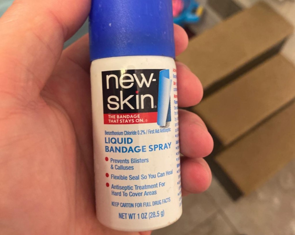 hand holding a spray can of new skin liquid bandage