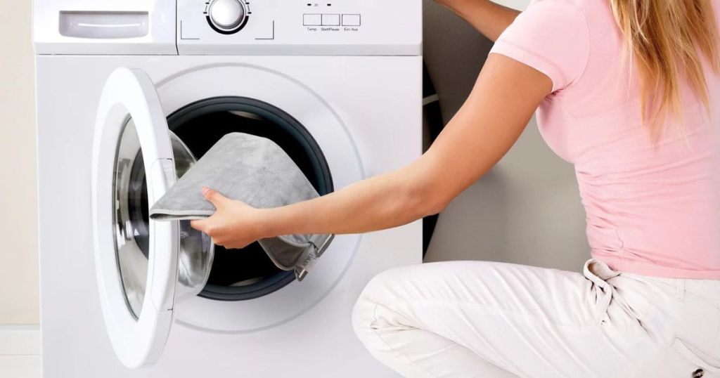 woman putting heating pad in washer