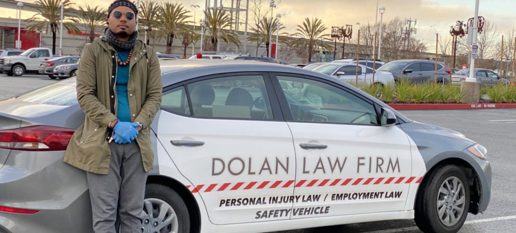 Man standing next to a car advertisement