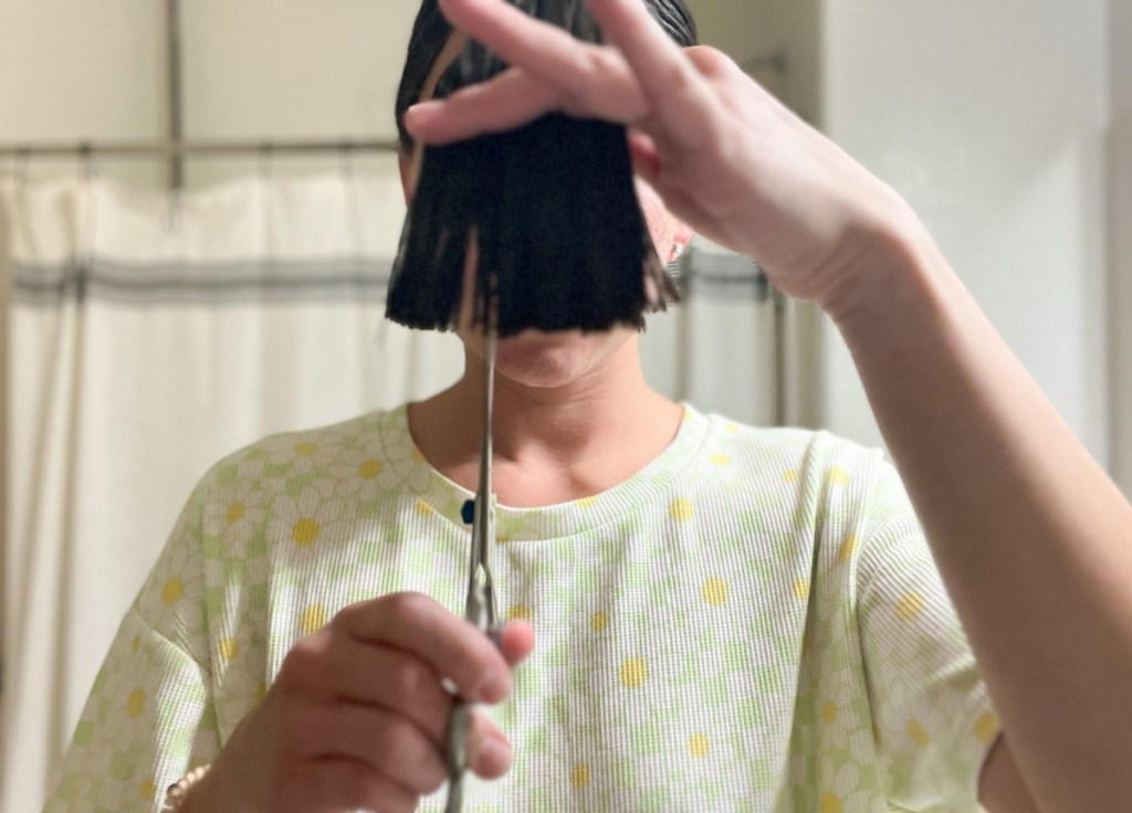 woman demonstrating how to cut your own hair