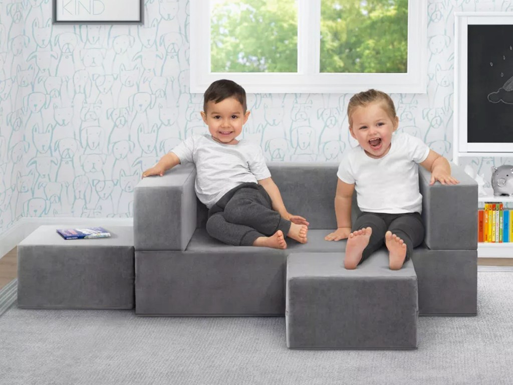 two boys on a grey modular sofa set in playroom