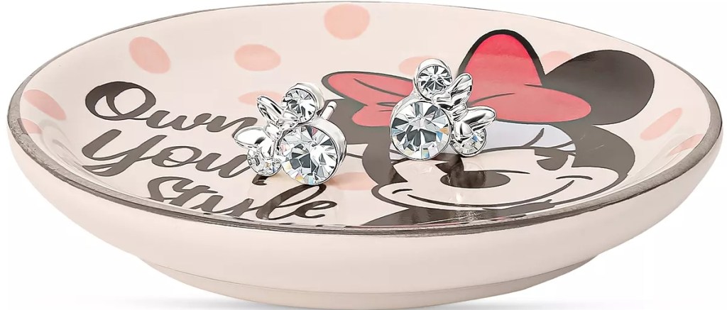 Pair of Disney earrings on a trinket plate with Minnie Mouse on it