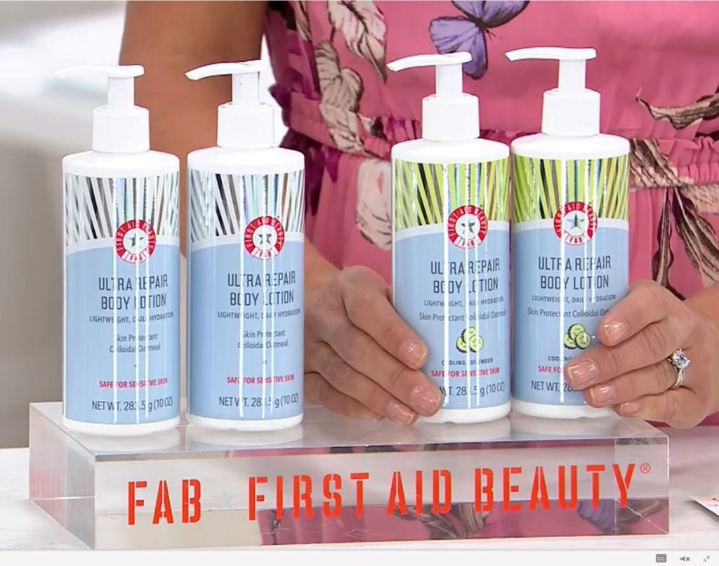 Four bottles of lotion with a woman standing behind them
