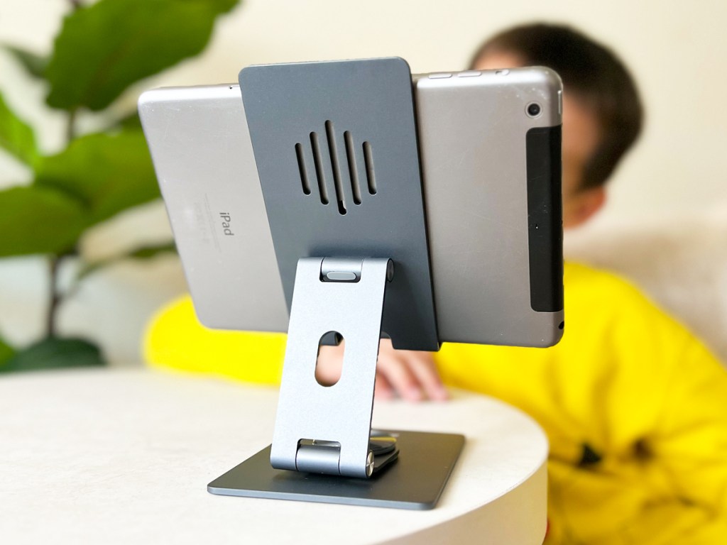 boy in yellow shirt looking at ipad on a stand