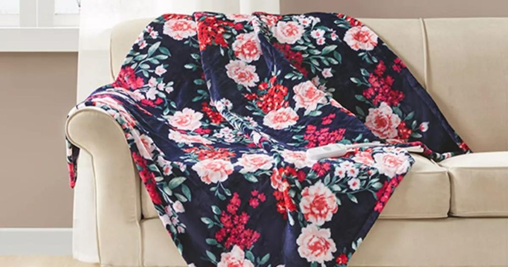 A floral print electric throw blanket draped on a couch