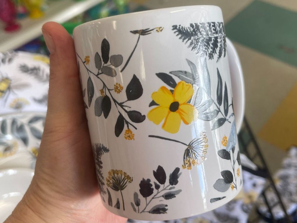 A mug with bees and yellow flowers on it. 