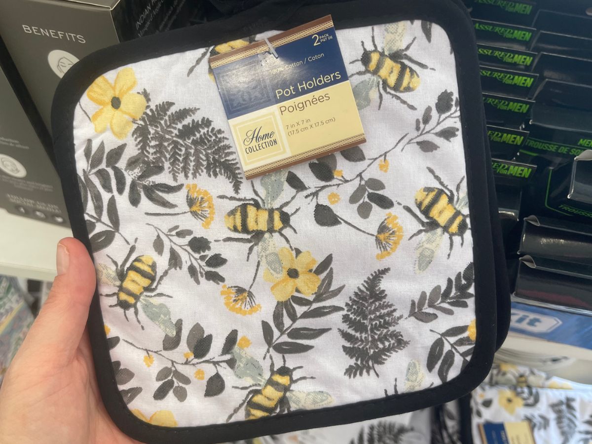 A potholder with bees and yellow flowers on it. 