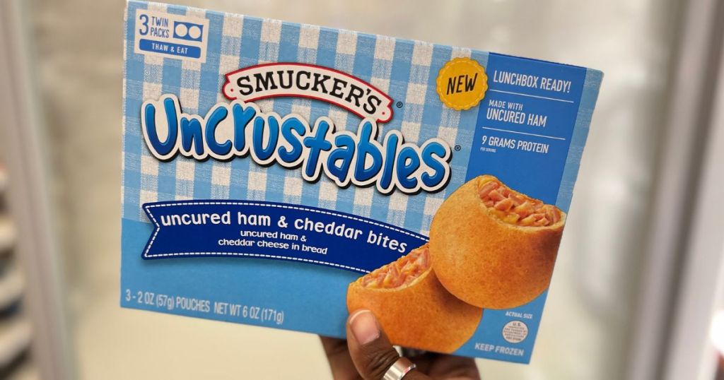 Hand holding up a box of Smucker's Uncrustable bites