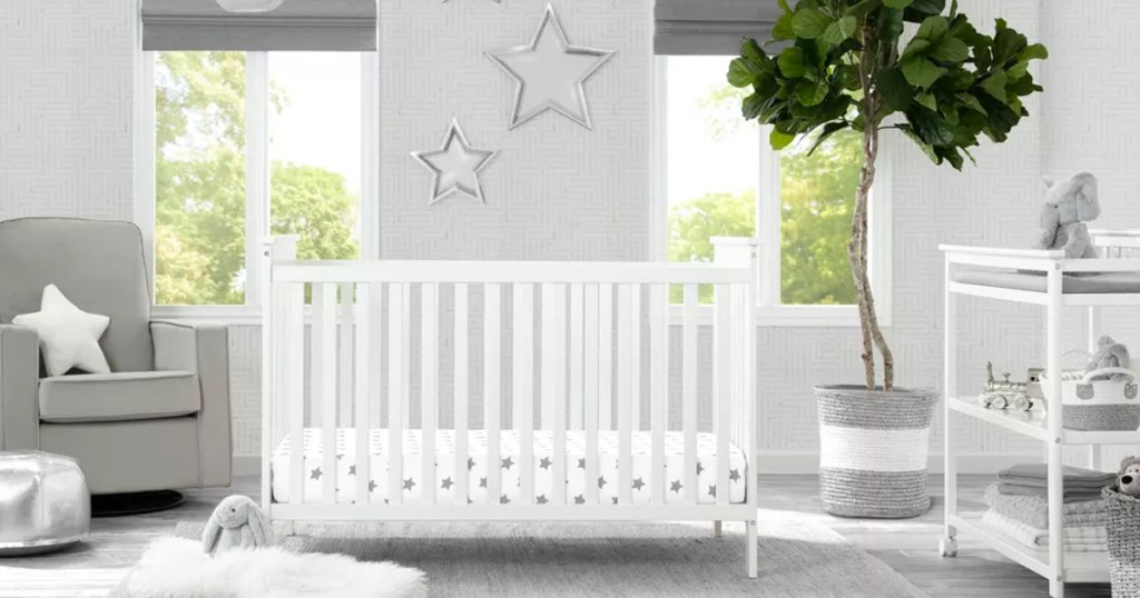 white crib in the middle of a nursery with rocking chair and changing table on either side