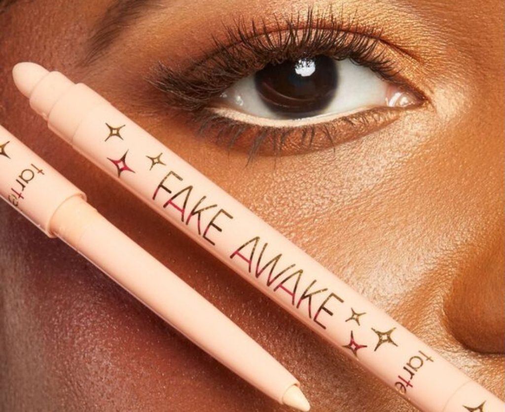 Eye with Tarte Fake Awake on the waterline with fake awake pencil held up to the cheek under the eye