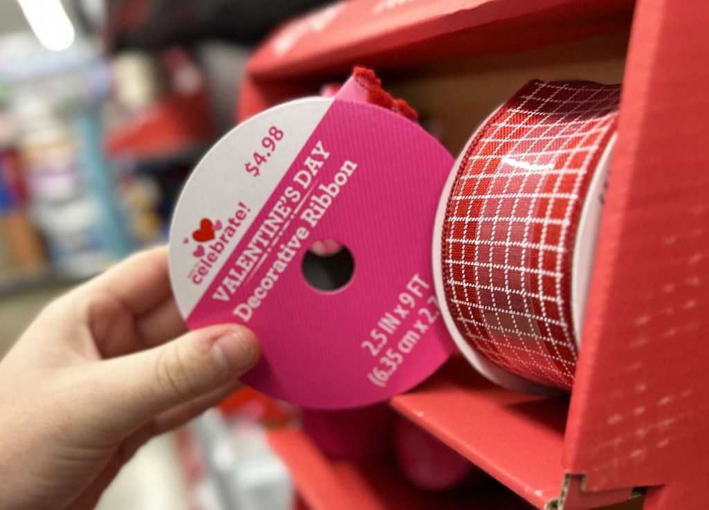 hand grabbing spool of valentines ribbon