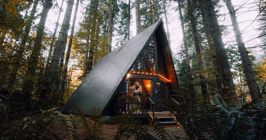 black a frame house with lights in woods