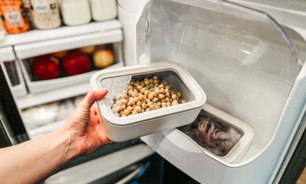 hand holding caraway food storage container with chickpeas inside