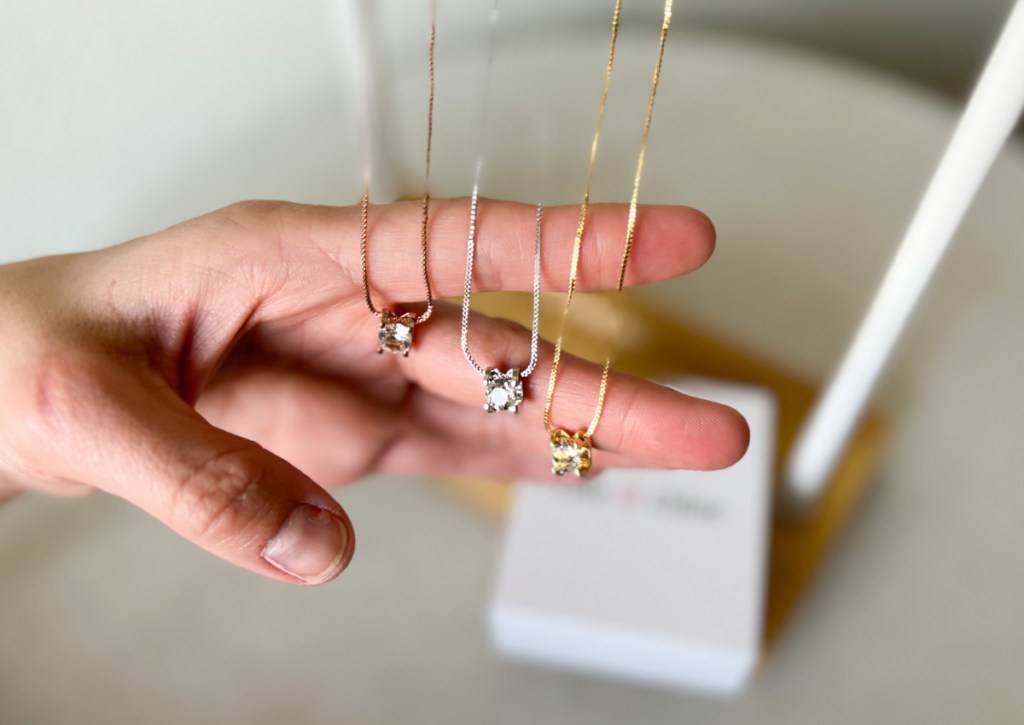 three necklaces draped over fingers