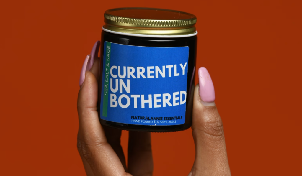 woman holding a "currently unbothered" small candle