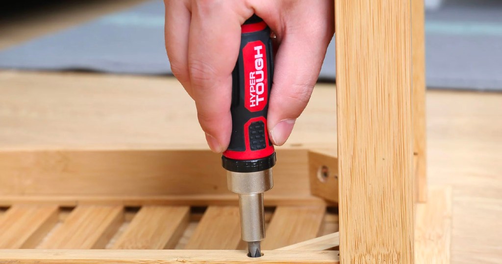 hand using hyper tough rachet screwdriver on table