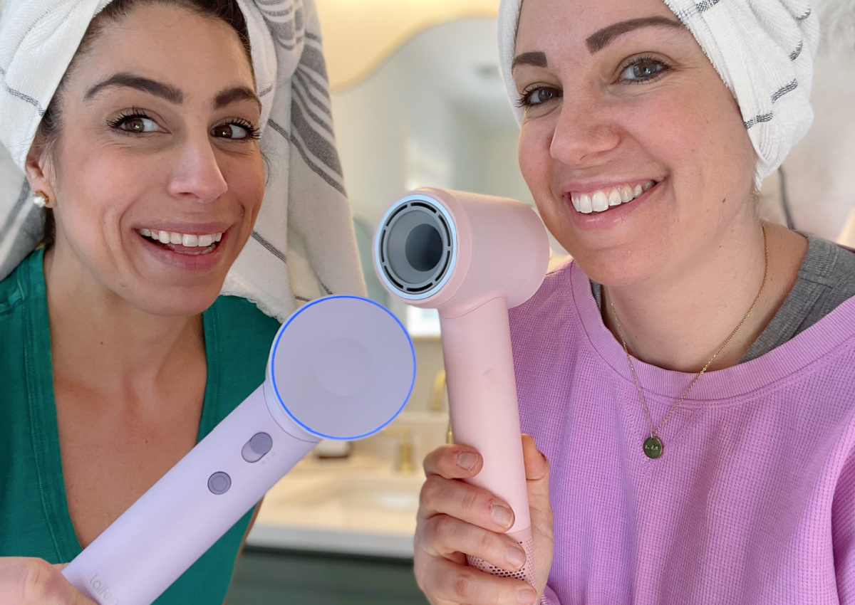 two women in hair towels holding hair dryers