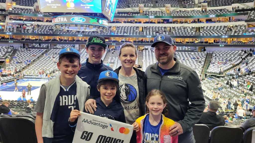 family standing at basketball stadium wearing mavericks gear