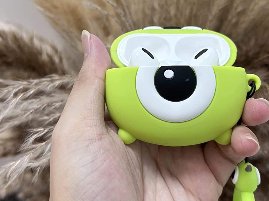 holding an open green Monsters Inc. AirPods case