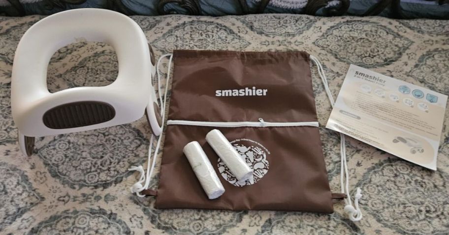 portable potty seat , carrying bag, and bags on table