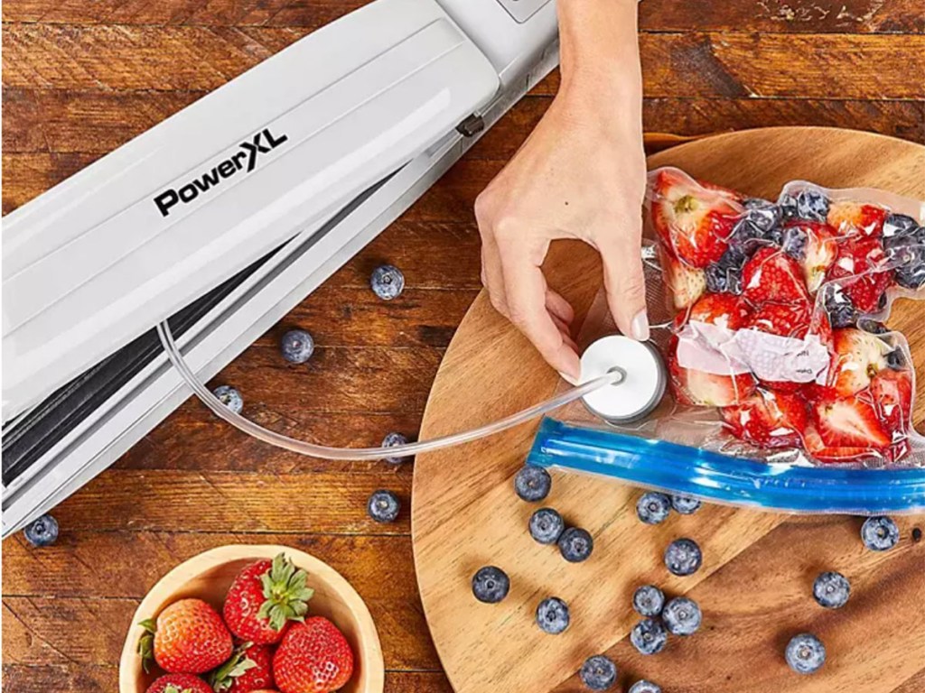 hand using powerxl sealer to seal fruit in bags