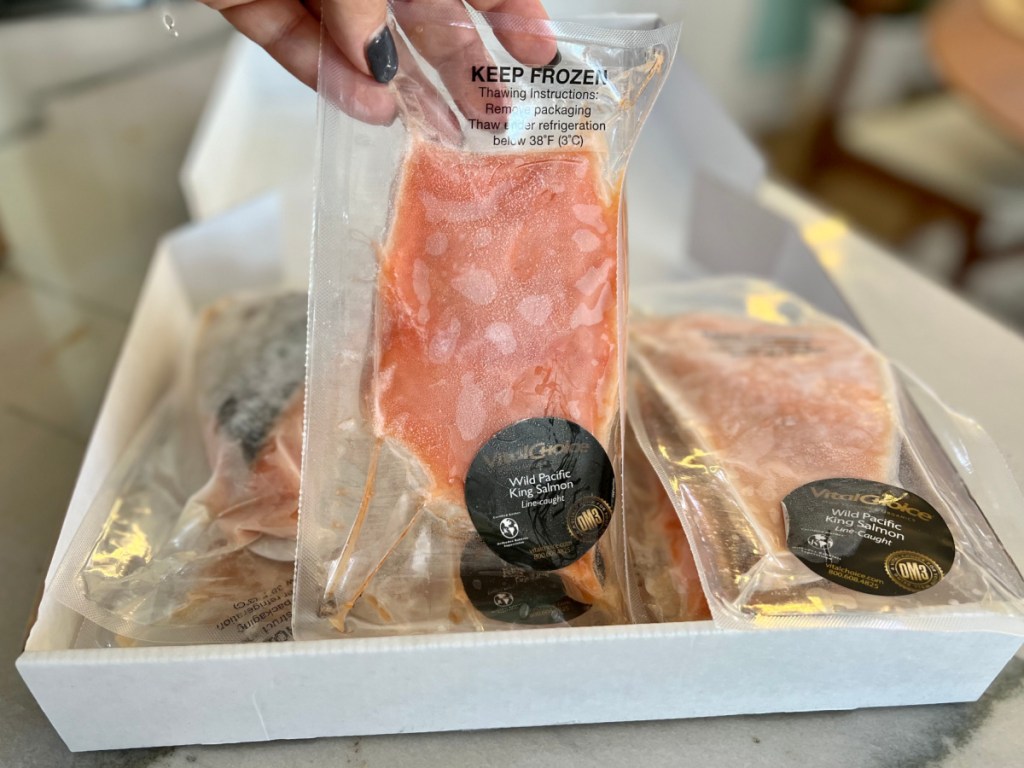 hand lifting frozen salmon