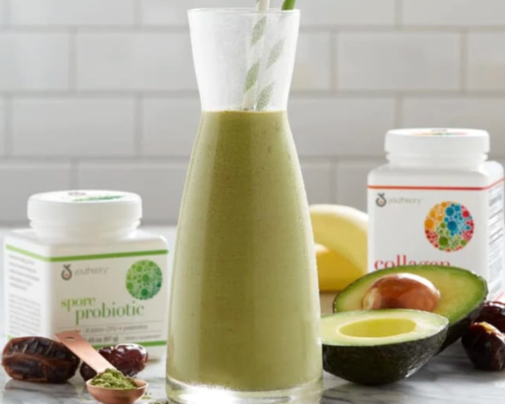 green smoothie next to vitamin bottles