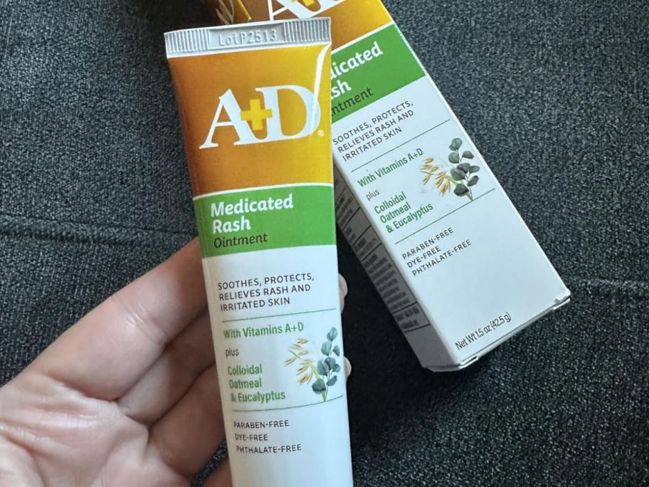 A persona holding A+Da ointment in their hand