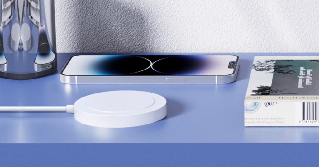 iphone on table next to white wireless charger