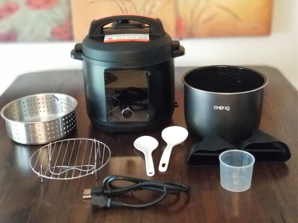 pressure cooker and accessories all laid out on wood table