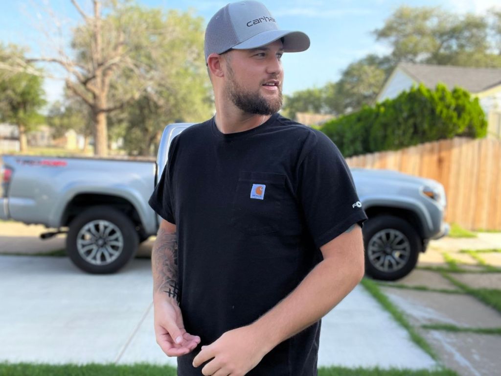 man wearing a Carhartt Tees while standing in front of a pickup truck