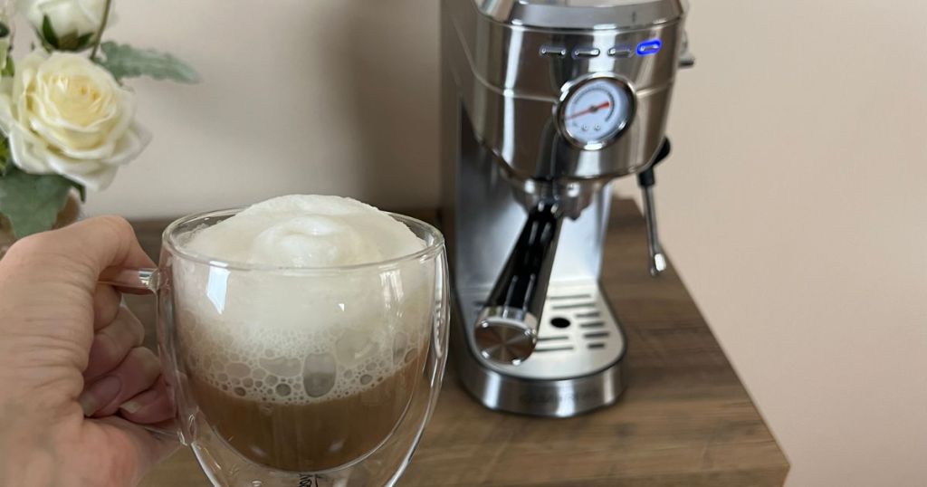 cappuccino in mug held up in front of a Casabrews Espresso Maker (1)