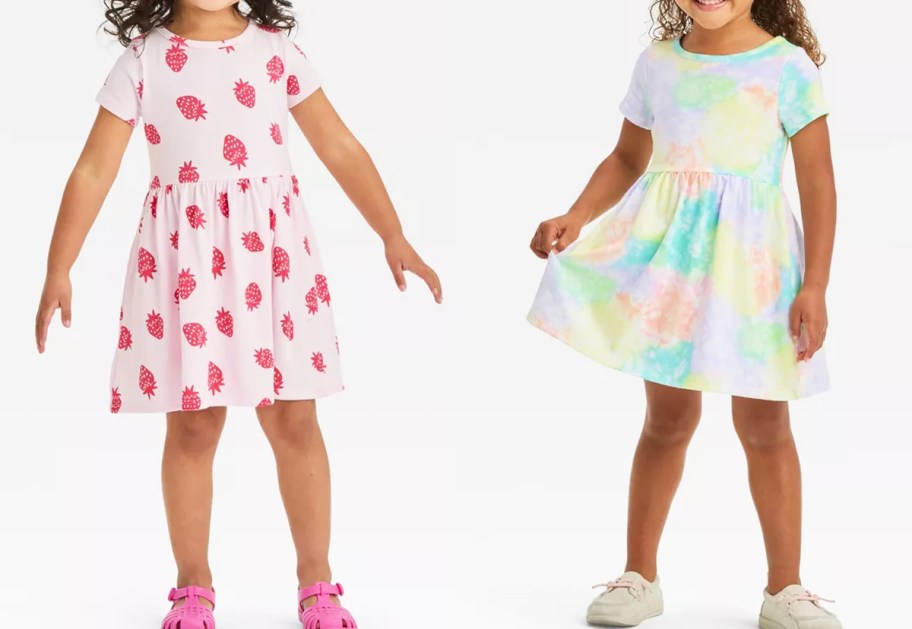 two girls in strawberry print and rainbow tie-dye dresses